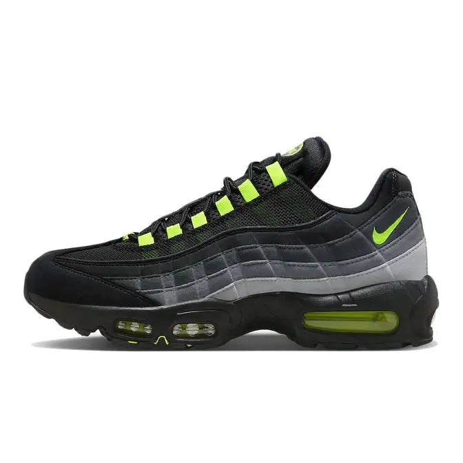 A sleek pair of Nike Air Max 95 sneakers in black with vibrant neon green accents. The shoes feature a layered upper design with mesh and suede overlays, a gradient effect transitioning from black to grey, and bold neon green highlights on the lace loops, Air Max branding, and visible Air cushioning units in the sole. The outsole is black with hints of neon, offering a striking and modern aesthetic, available at Shoe Xport.