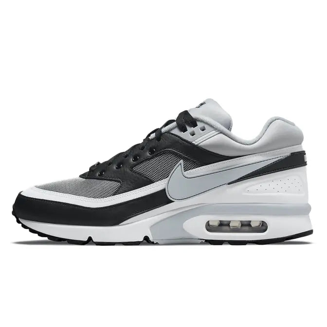 Side view of the Nike Air Max BW Lyon sneaker, featuring a vibrant red upper with white and navy accents inspired by Olympique Lyonnais. The design includes mesh and synthetic materials, the iconic large Air unit in the heel, and a clean white midsole for a bold and sporty look. Available at Shoe Xport.